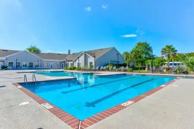 Bright blue swimming pool with loungers exterior at Stadium Suites in Columbia Student Accommodation