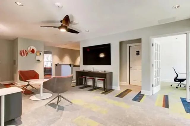 Modern living room with chairs and TV at Stadium Suites in Columbia Student Accommodation