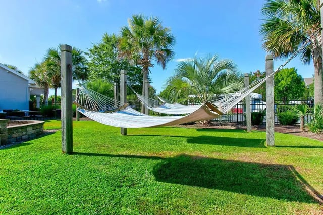 Hammocks strung between posts on green lawn outdoor area at Stadium Suites in Columbia Student Accommodation
