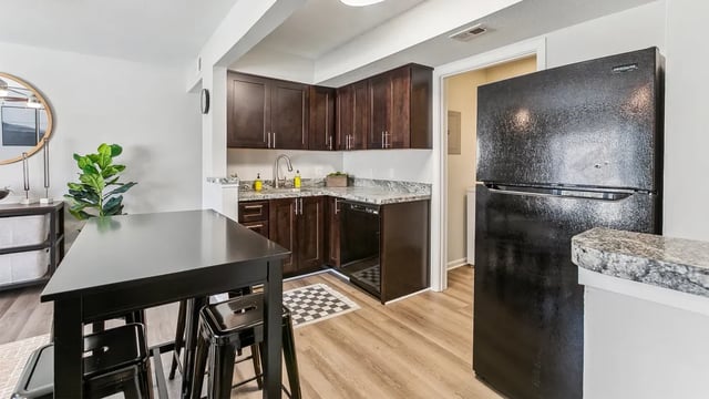 Black dining table with stools and modern kitchen kitchen at Maison Burbank in Baton Rouge Student Accommodation