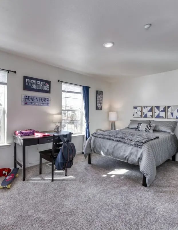 Bed desk chair backpack skateboard bedroom at Copper Beech Townhomes in Clovis Student Accommodation