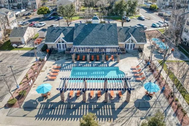 Pool lounge chairs umbrellas and basketball court exterior at Copper Beech Townhomes in Clovis Student Accommodation