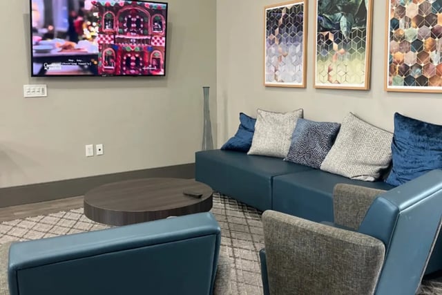Blue couch tv artwork modern coffee table living room at Copper Beech Townhomes in Clovis Student Accommodation