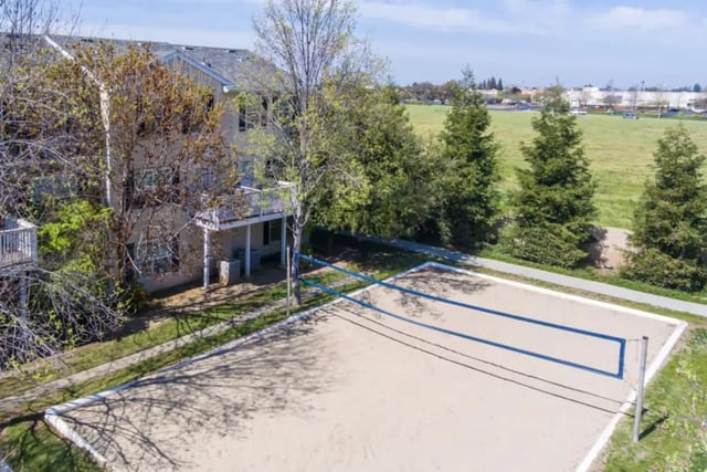 Apartment building with volleyball court exterior at Copper Beech Townhomes in Clovis Student Accommodation