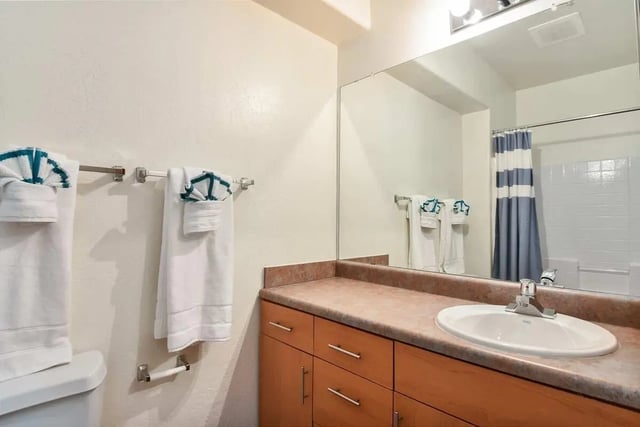 Toilet towels vanity sink and shower curtain bathroom at Clear Creek Village Apartments in Flagstaff Student Accommodation