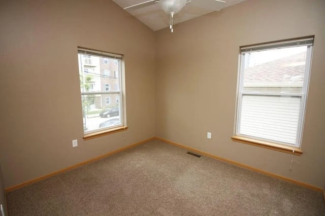 Empty room with tan walls two windows and carpet bedroom at Conner Crossing Apartments -"The Porches" in West Lafayette Student Accommodation