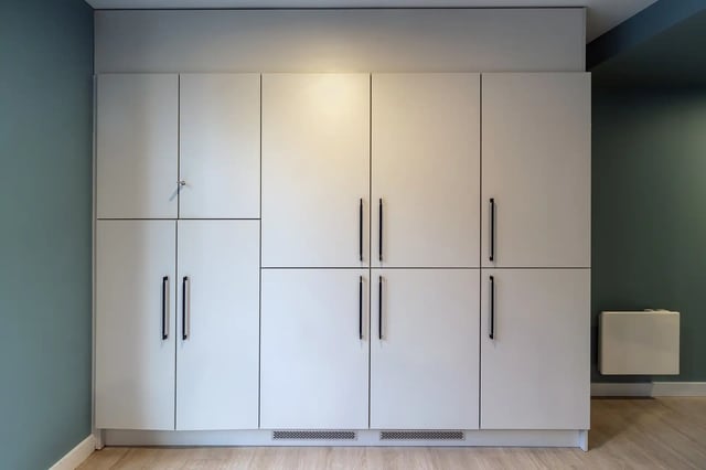 Tall white cabinets with black handles storage area at Queen Street Place in Galway Student Accommodation