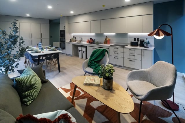 Sofa chairs coffee table dining table kitchen living room at Queen Street Place in Galway Student Accommodation
