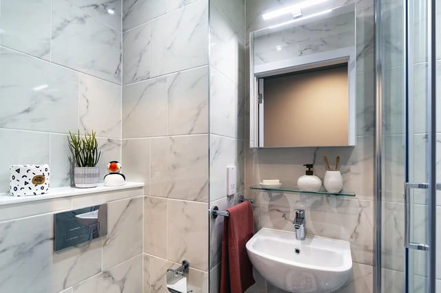 Modern marble bathroom with sink mirror and shower. at Queen Street Place in Galway Student Accommodation