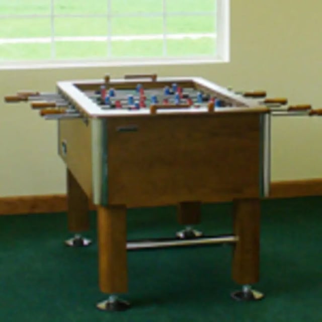 Foosball table with red blue players playing area at Aspen Court Apartments in Macomb Student Accommodation