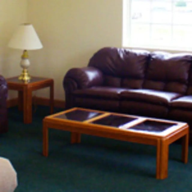 Leather sofa lamp coffee table living room at Aspen Court Apartments in Macomb Student Accommodation