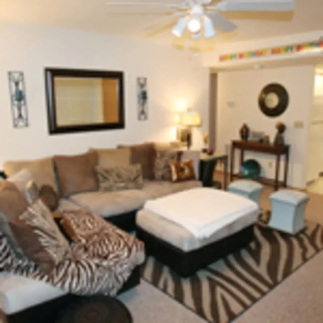 Sofa ottoman and rugs living room at Aspen Court Apartments in Macomb Student Accommodation