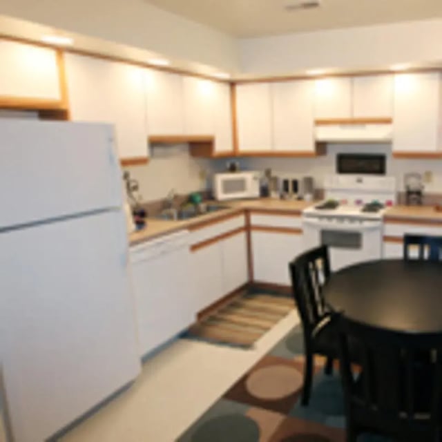 Refrigerator stove microwave dining table kitchen at Aspen Court Apartments in Macomb Student Accommodation