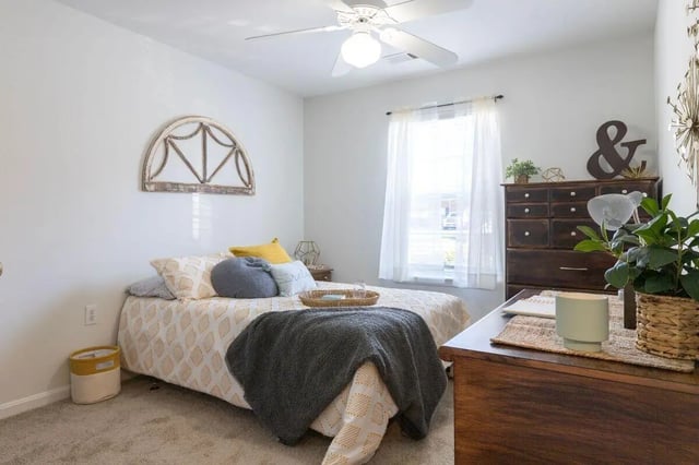 Bed with patterned duvet and dark dresser bedroom at Belmont Landing in Farmville Student Accommodation
