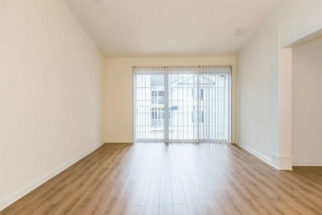 Empty room with sliding glass doors and wood floors living room at Belmont Landing in Farmville Student Accommodation