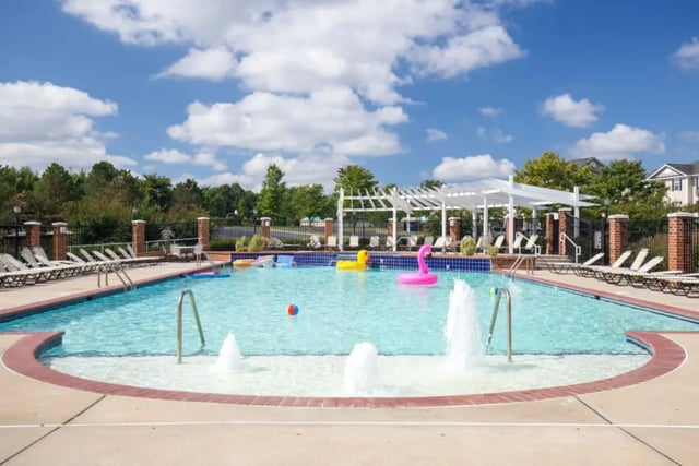 Pool with lounge chairs inflatable toys and fountains pool at Belmont Landing in Farmville Student Accommodation