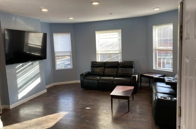 Black leather couches and tables living room at Colonnade Rentals in Oneonta Student Accommodation