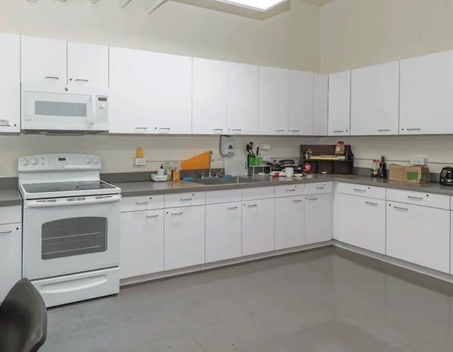 White cabinets microwave stove sink area kitchen at 5748 Blackstone by 3L Living in Chicago Student Accommodation