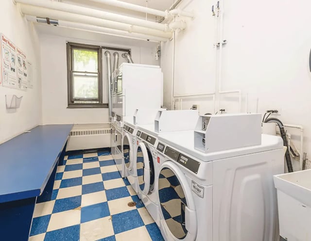 Row of washing machines blue counter laundry room at 5748 Blackstone by 3L Living in Chicago Student Accommodation