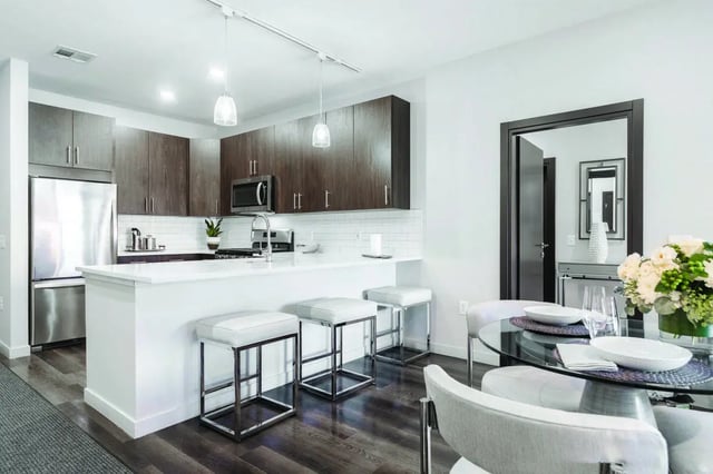 Modern kitchen with island dining table stools living room at 58 E. Main St. Apartments in Newark Student Accommodation