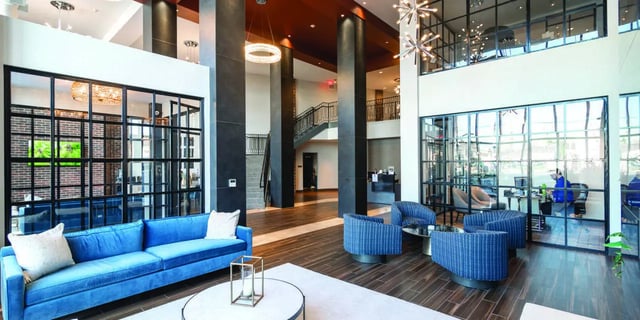 Blue sofa armchairs and coffee table lounge area at 58 E. Main St. Apartments in Newark Student Accommodation