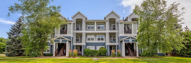 Apartment building with balconies stairs and trees Exterior at 58 West - Lease by Bed Available in Kalamazoo Student Accommodation