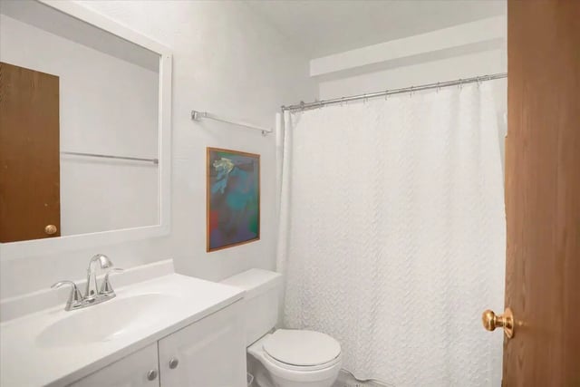Sink toilet mirror shower curtain bathroom at Cedar Lofts East Apartments in State College Student Accommodation