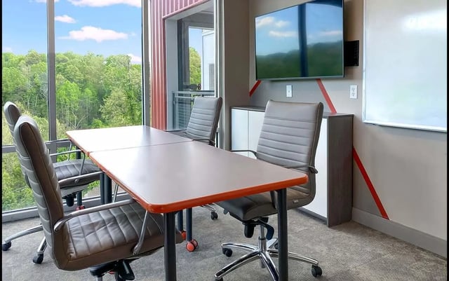 Table chairs television whiteboard study area at Cedar Pointe Apartments in Blacksburg Student Accommodation