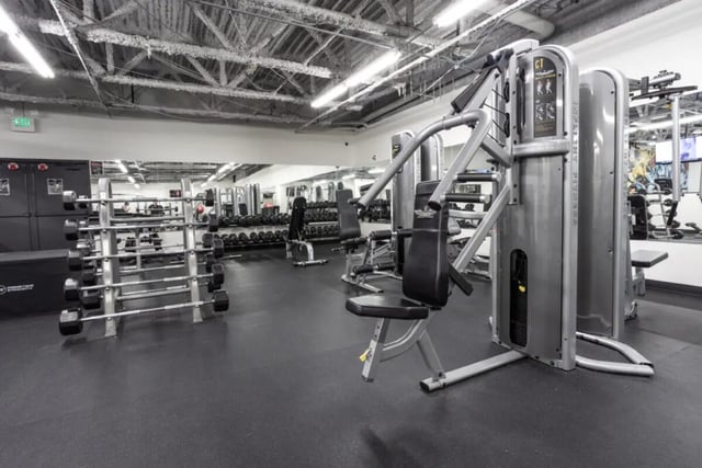 Weight machines and dumbbells in gym area at Assembly Student Living in Denver Student Accommodation