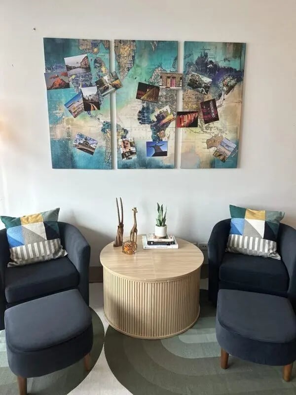 Two chairs ottoman world map wall art living room at Assembly Student Living in Denver Student Accommodation