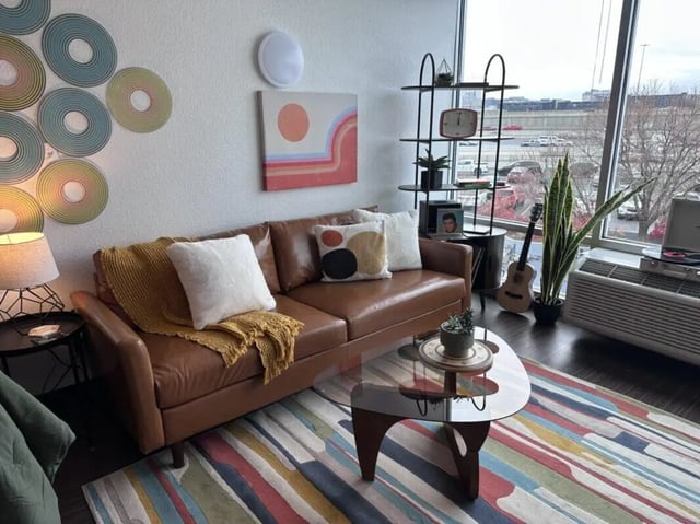 Brown sofa colorful rug records and guitar living room at Assembly Student Living in Denver Student Accommodation