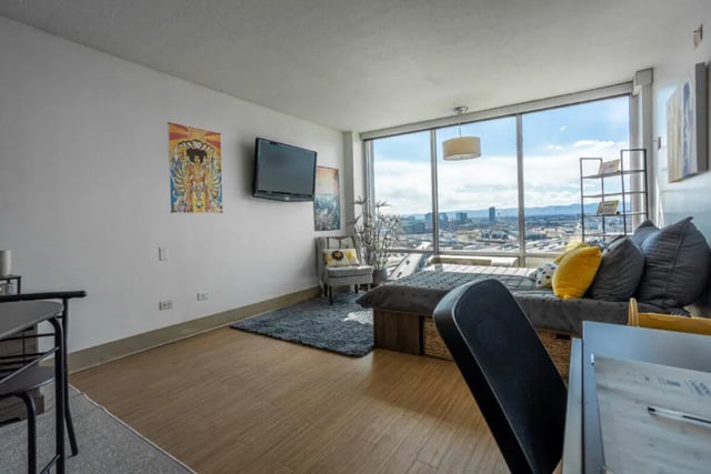 TV shelf daybed pillows and city view living room at Assembly Student Living in Denver Student Accommodation
