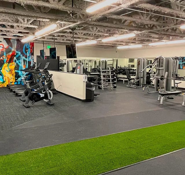 Spin bikes weight machines dumbbells gym floor interior at Assembly Student Living in Denver Student Accommodation
