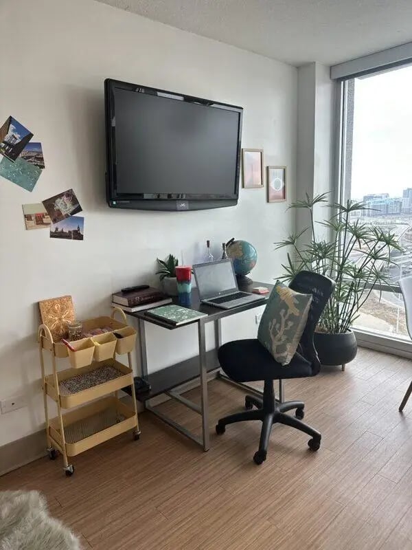 Desk with laptop plants TV and cart study area at Assembly Student Living in Denver Student Accommodation