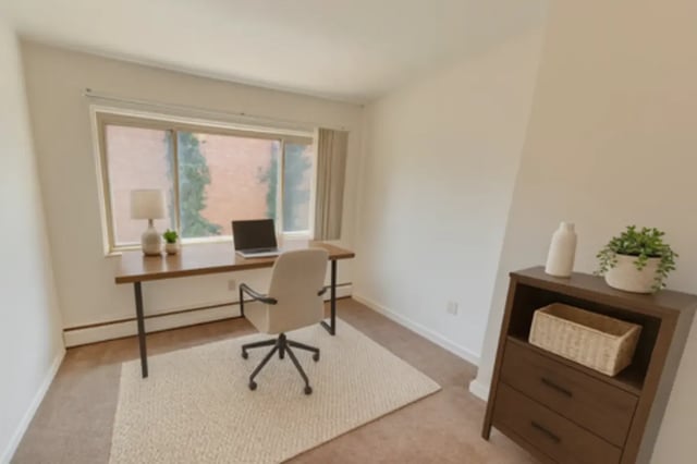 Desk laptop chair rug and plant study area at Cedar Street Apartments in East Lansing Student Accommodation