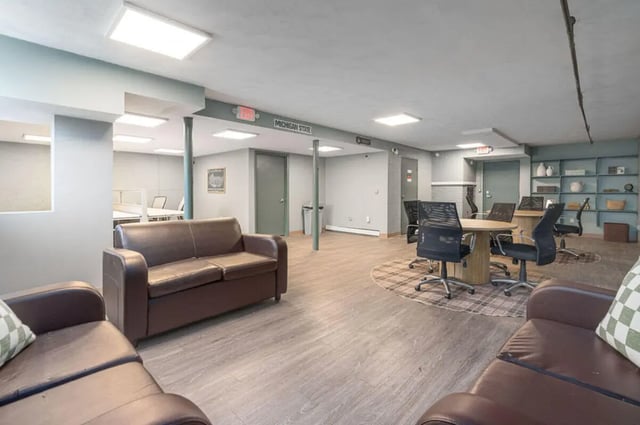 Brown couches round table chairs communal area at Cedar Street Apartments in East Lansing Student Accommodation