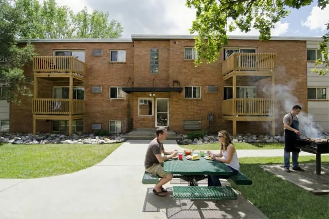 Couple eating picnic barbecue exterior at Cedar Street Apartments in East Lansing Student Accommodation