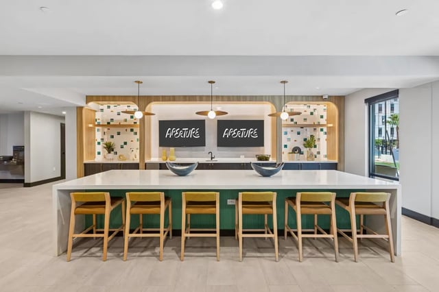Bar with stools and screens community kitchen at Aperture in Orlando Student Accommodation