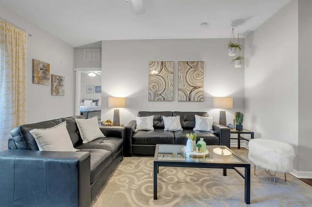 Black sofas coffee table artwork living room at West 10 Apartments in Tallahassee Student Accommodation