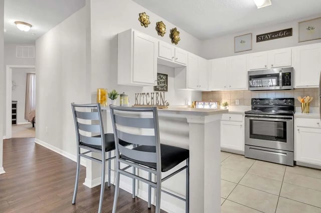 Two stools at counter next to kitchen appliance kitchen at West 10 Apartments in Tallahassee Student Accommodation