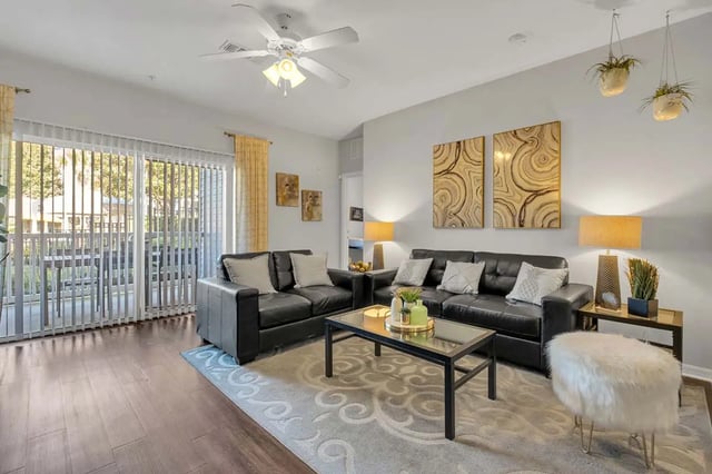 Black sofas glass coffee table living room at West 10 Apartments in Tallahassee Student Accommodation