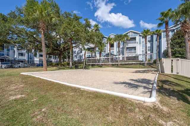 Volleyball court with apartments and palm trees exterior at West 10 Apartments in Tallahassee Student Accommodation
