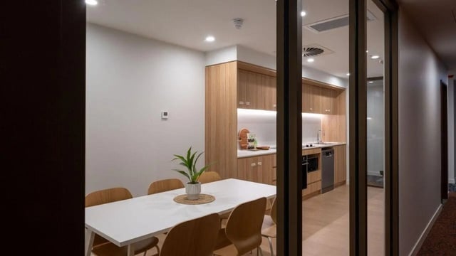 White table wooden chairs modern kitchen area dining room at UniLodge Brisbane City in Brisbane Student Accommodation