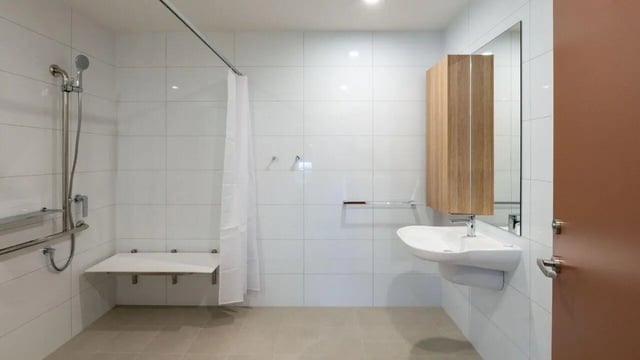 Shower with seat sink and wooden cabinet bathroom at UniLodge Brisbane City in Brisbane Student Accommodation