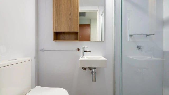 Toilet sink cabinet mirror and shower enclosure bathroom at UniLodge Brisbane City in Brisbane Student Accommodation