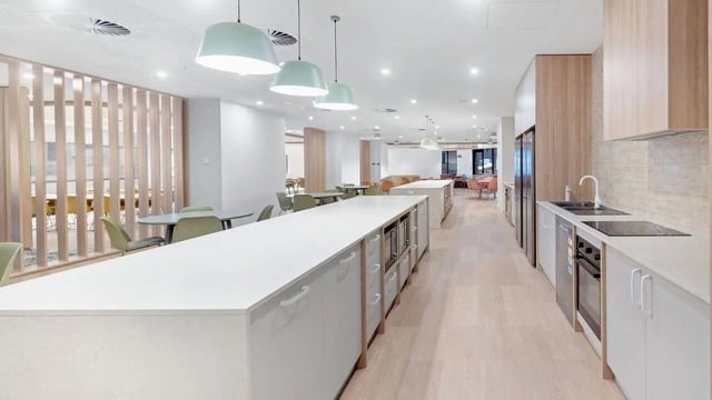 Long kitchen island with microwaves and dining area kitchen at UniLodge Brisbane City in Brisbane Student Accommodation