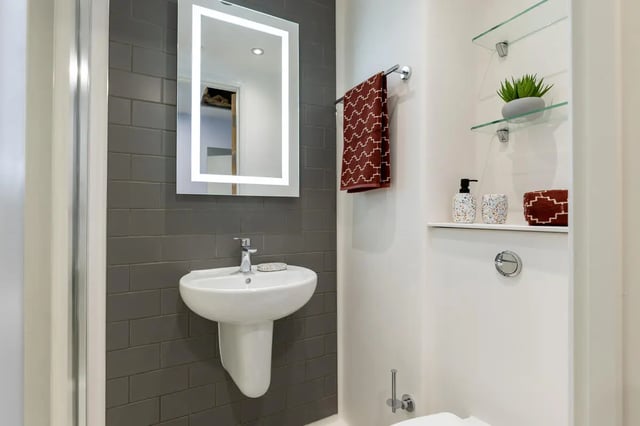 Pedestal sink illuminated mirror towel rack bathroom at Croft Court in Bristol Student Accommodation