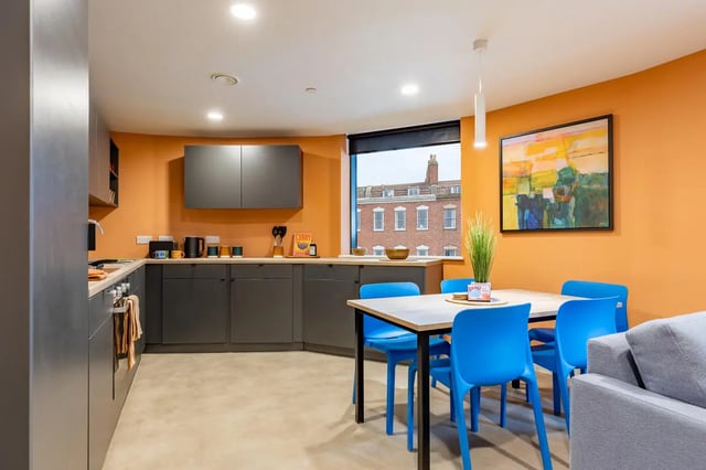 Modern kitchen with dining table and blue chairs kitchen at Croft Court in Bristol Student Accommodation