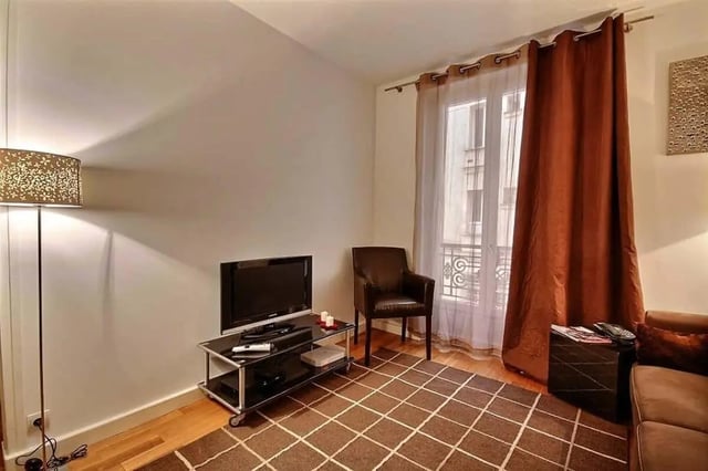 Floor lamp TV brown chair large window living room at Apartment in Rue Claude Terrasse, 75016 Paris, France in Paris Student Accommodation