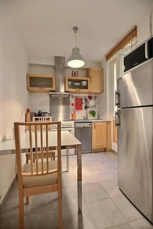 Table chairs refrigerator cabinets stove sink kitchen at Apartment in Rue Claude Terrasse, 75016 Paris, France in Paris Student Accommodation